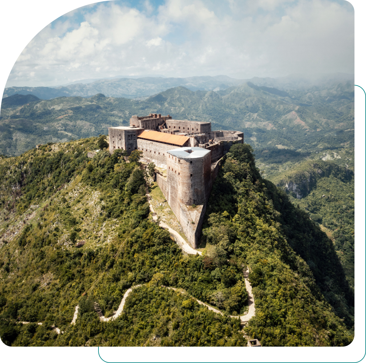 Mountain-top fortress surrounded by lush landscape.