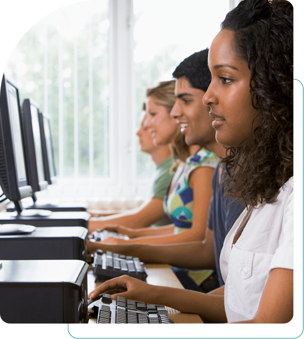 Students focused on working at computers in a classroom.
