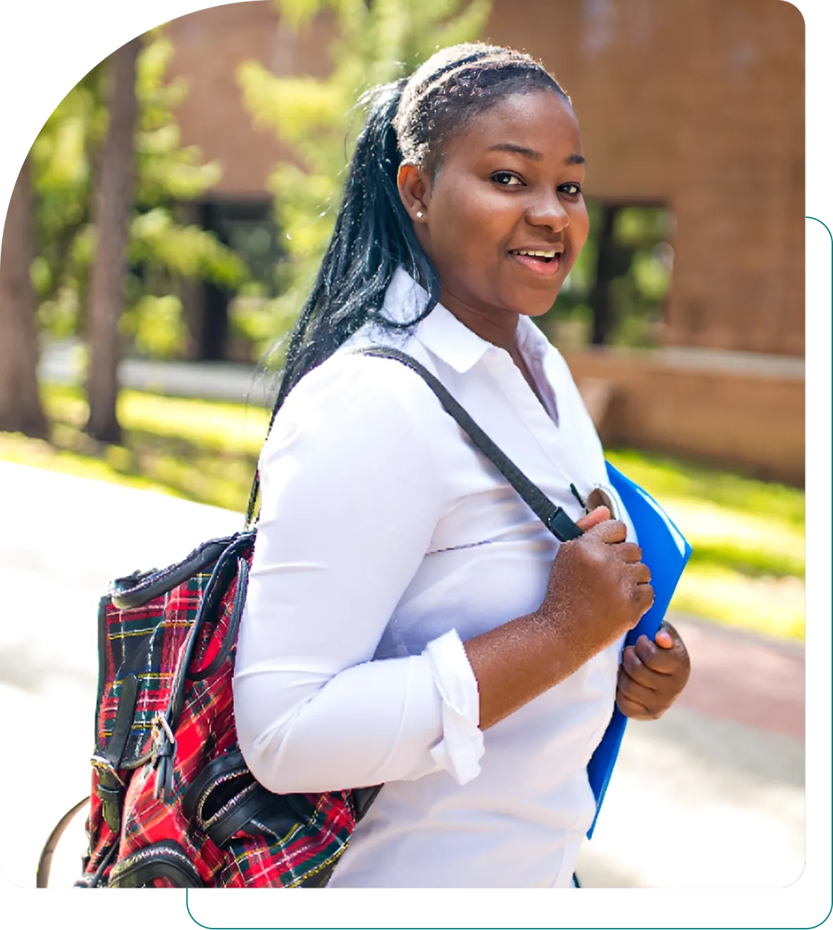 Smiling student with backpack and folder outside.